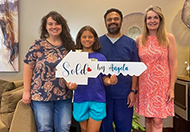 Angela Reagan presenting sold key sign to a client.